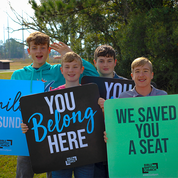 teenagers holding welcome signs