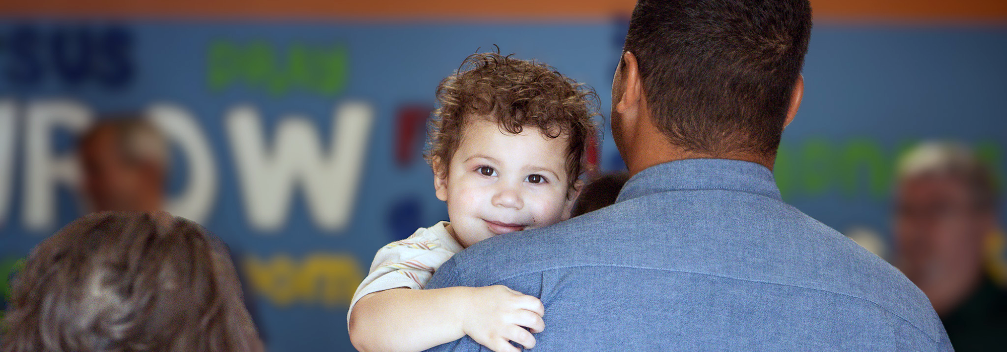 toddler looking over dads shoulder